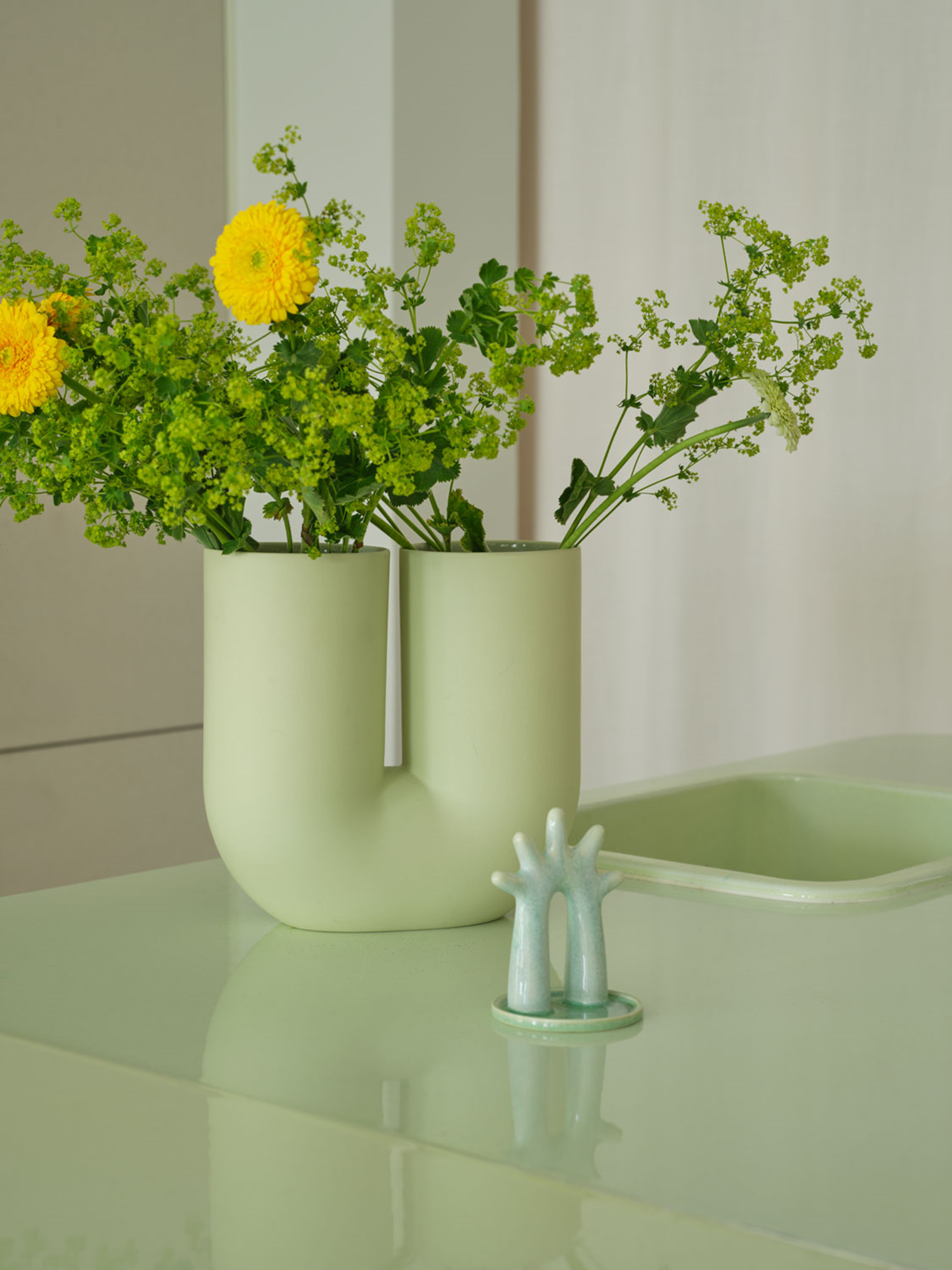 A Muuto Kink vase 26 cm in light green, characterized by its modern, twisted design. The gentle green color and unique form is an elegant addition to any room.